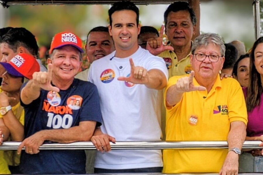 Nabor Wanderley, Lucas Ribeiro e João Azevêdo sorriem em veículo aberto fazendo gesto de campanha com os dedos