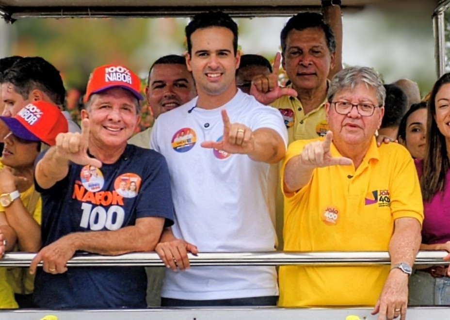 Nabor Wanderley, Lucas Ribeiro e João Azevêdo sorriem em veículo aberto fazendo gesto de campanha com os dedos