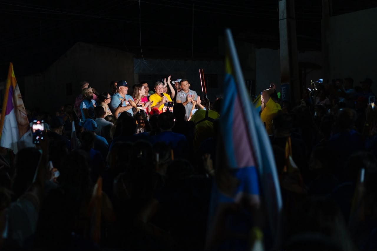 João Azevêdo discursa ao microfone ao lado de Olívia Motta e Jacob Souto durante comício noturno em Patos.